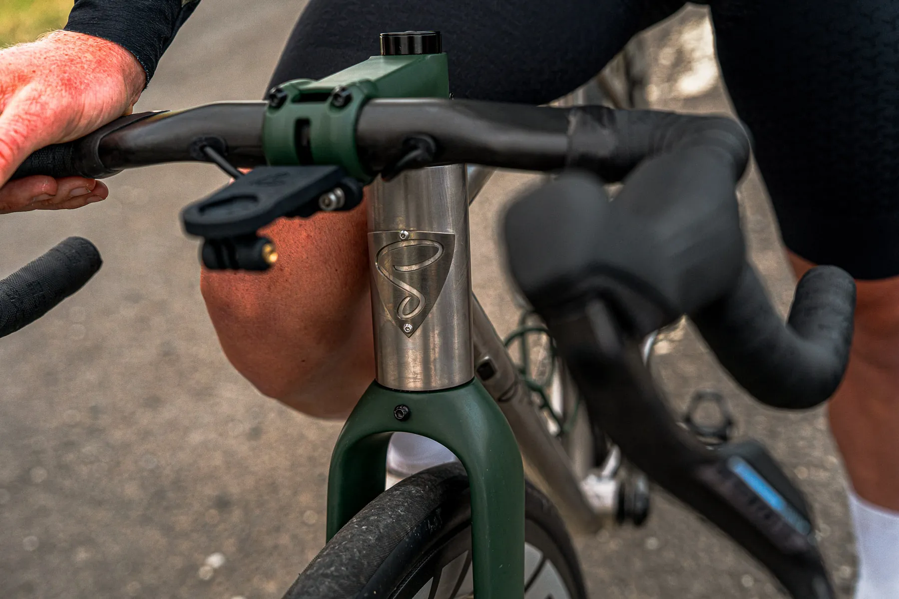 Close detail of titanium head tube with green Cerakote fork and stem.